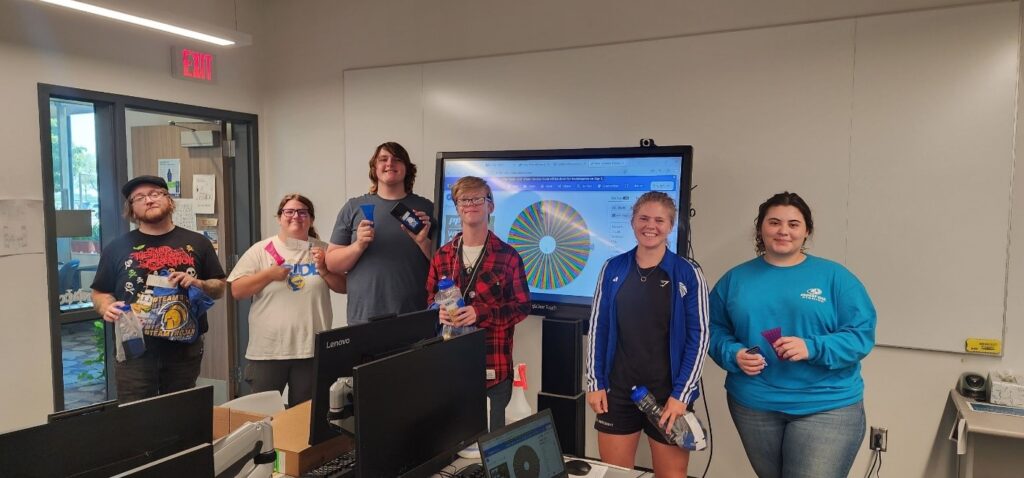 Bridge Program students holding up prizes and NIACC swag that they won.