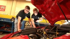 Photo of students working on a car in the Automotive program