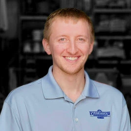 Man smiling at camera wearing a blue polo shirt