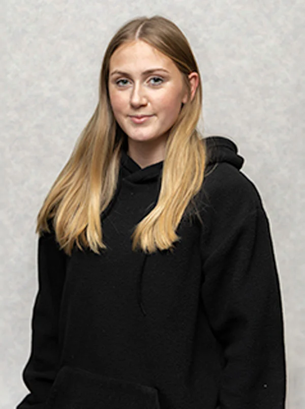 Female with long blonde hair wearing a black hoodie